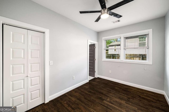 unfurnished bedroom featuring dark wood-style flooring, baseboards, a ceiling fan, and visible vents