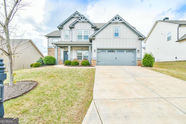 craftsman house with board and batten siding, driveway, a front lawn, and brick siding