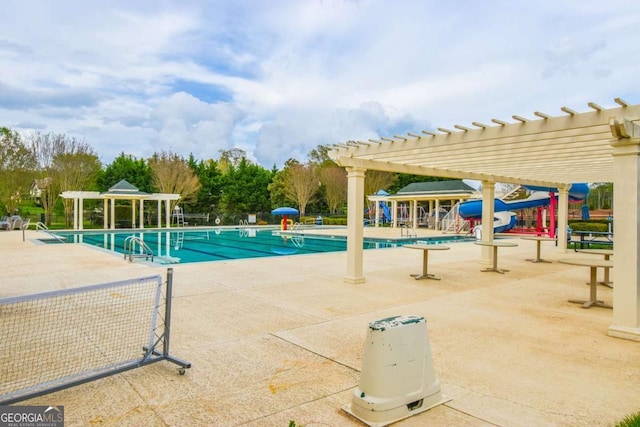pool featuring a pergola, playground community, and a patio area