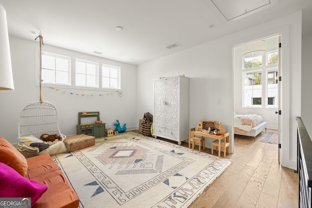 game room with light wood-type flooring, attic access, and visible vents