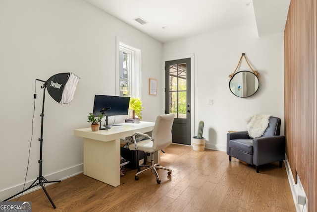 office area featuring visible vents, baseboards, and wood finished floors
