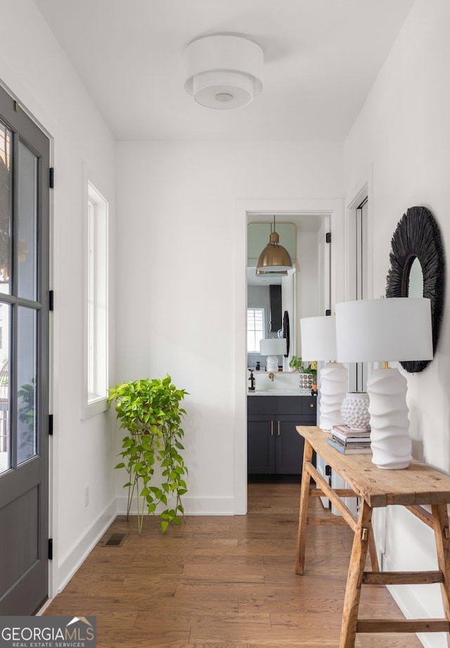 foyer with visible vents, baseboards, and light wood-type flooring