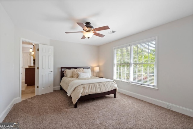 carpeted bedroom with visible vents, baseboards, and ceiling fan