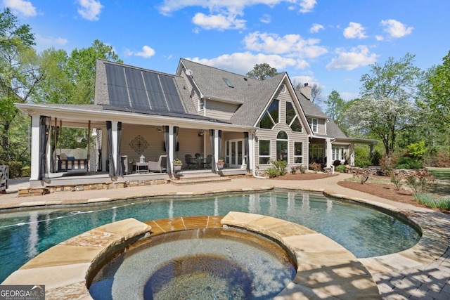 view of pool featuring a patio and a pool with connected hot tub