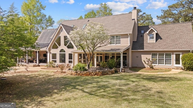rear view of property featuring a lawn