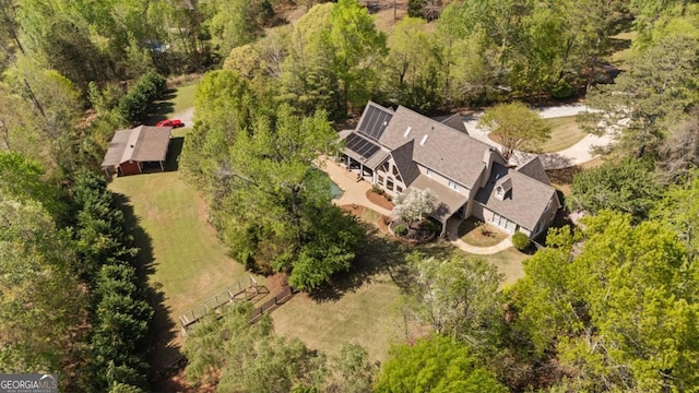 birds eye view of property featuring a forest view