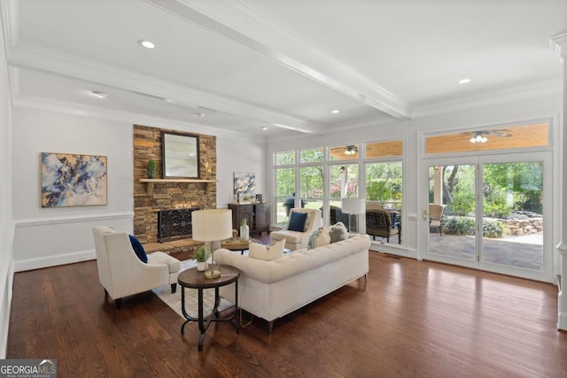 living area with a fireplace, dark wood-style floors, a ceiling fan, crown molding, and beamed ceiling