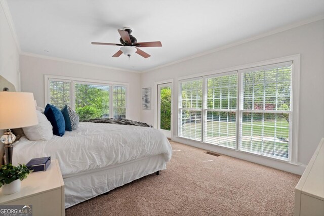 bedroom with ceiling fan, ornamental molding, and carpet floors