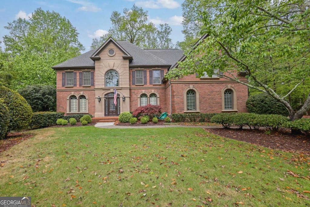 view of front facade featuring brick siding and a front lawn