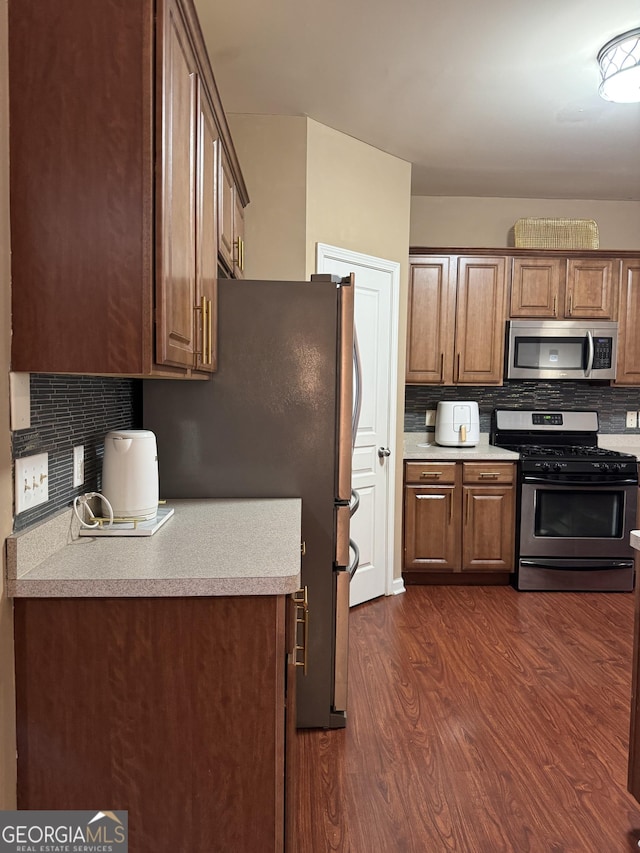 3627 Mcclaren Way, Lawrenceville, GA 30044 - kitchen with dark wood finished floors, light countertops, decorative backsplash, and appliances with stainless steel finishes