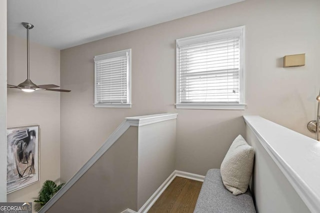 interior space with baseboards, an upstairs landing, and wood finished floors