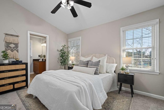 carpeted bedroom with ceiling fan, ensuite bathroom, baseboards, and lofted ceiling