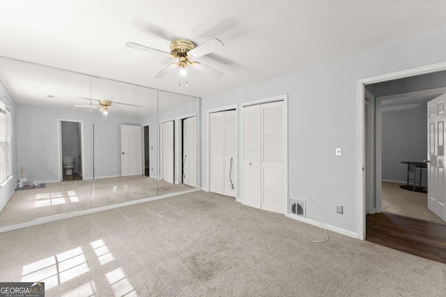 6500 Gaines Ferry Rd, Flowery Branch, GA 30542 - unfurnished bedroom featuring visible vents, baseboards, ceiling fan, multiple closets, and carpet flooring