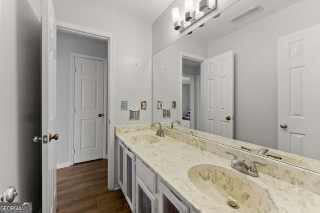6500 Gaines Ferry Rd, Flowery Branch, GA 30542 - bathroom featuring a sink, visible vents, double vanity, and wood finished floors