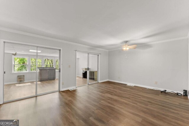 6500 Gaines Ferry Rd, Flowery Branch, GA 30542 - unfurnished bedroom with baseboards, crown molding, visible vents, multiple closets, and wood finished floors