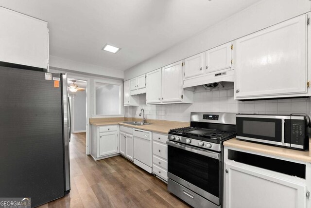 6500 Gaines Ferry Rd, Flowery Branch, GA 30542 - kitchen with stainless steel appliances, under cabinet range hood, white cabinetry, and a sink