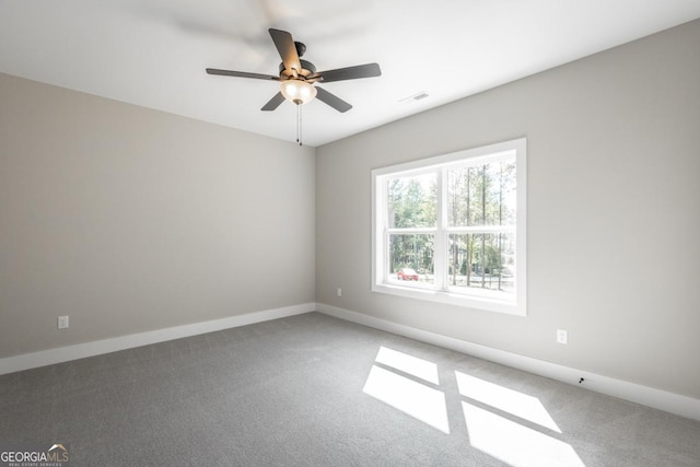 carpeted empty room featuring visible vents, baseboards, and a ceiling fan