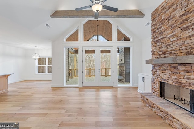unfurnished living room featuring visible vents, a ceiling fan, a fireplace, french doors, and light wood-style flooring