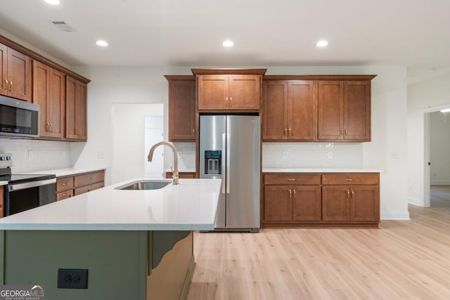 kitchen featuring light wood-style flooring, light countertops, visible vents, stainless steel appliances, and a sink