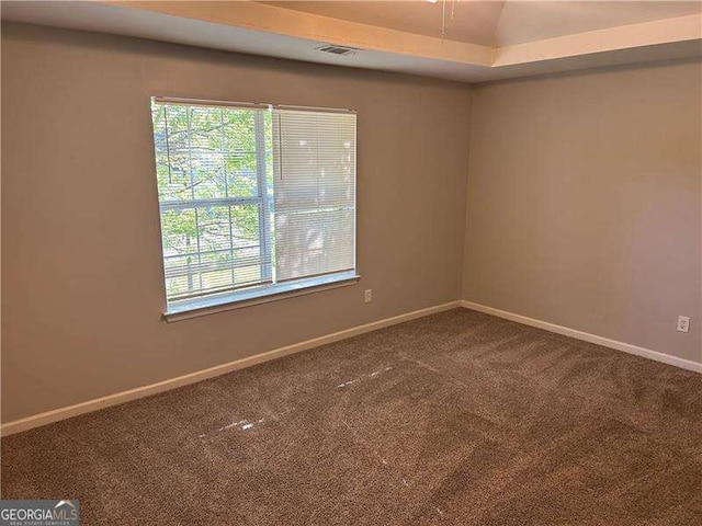 empty room featuring visible vents, baseboards, and carpet floors