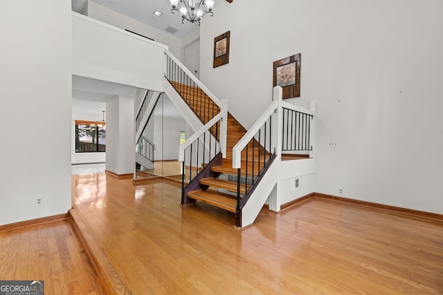 890 Muirfield Rdg, Marietta, GA 30068 - staircase with hardwood / wood-style floors, a high ceiling, a notable chandelier, and baseboards