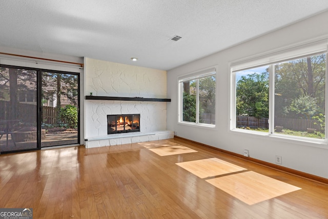 890 Muirfield Rdg, Marietta, GA 30068 - unfurnished living room with a textured ceiling, a fireplace, visible vents, and hardwood / wood-style flooring