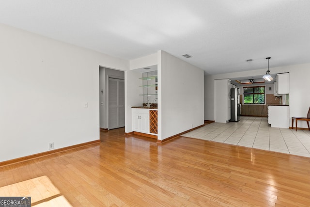 890 Muirfield Rdg, Marietta, GA 30068 - unfurnished living room with visible vents, baseboards, and light wood-style floors