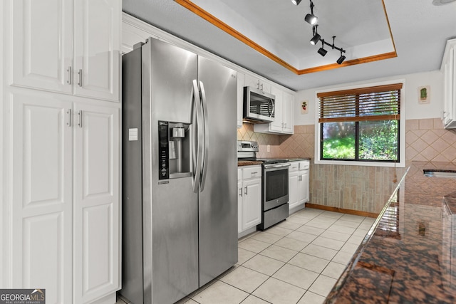 890 Muirfield Rdg, Marietta, GA 30068 - kitchen featuring light tile patterned floors, white cabinetry, dark countertops, a tray ceiling, and appliances with stainless steel finishes