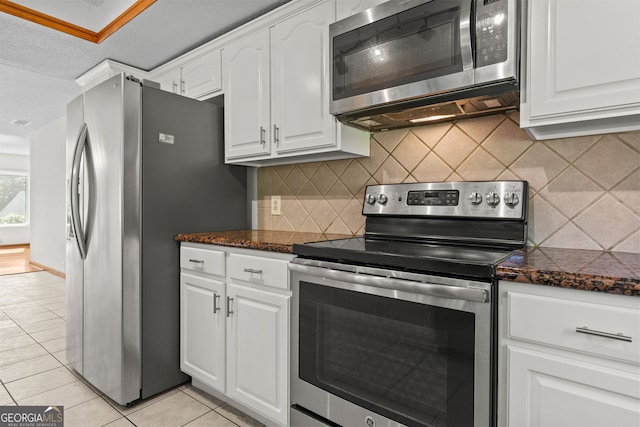890 Muirfield Rdg, Marietta, GA 30068 - kitchen with light tile patterned floors, backsplash, white cabinetry, and stainless steel appliances