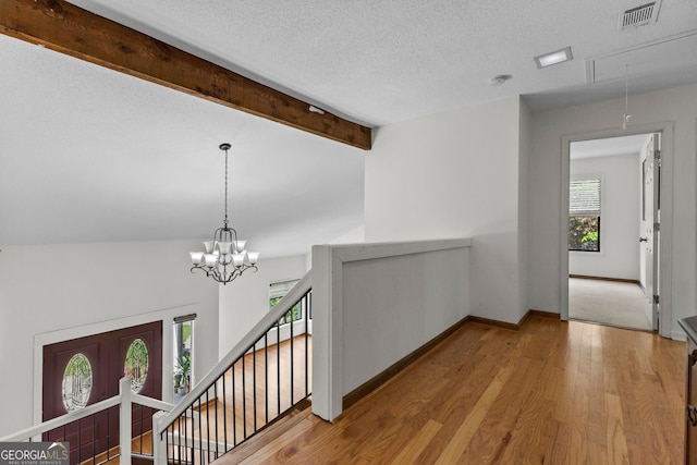 890 Muirfield Rdg, Marietta, GA 30068 - hallway featuring visible vents, baseboards, an upstairs landing, a textured ceiling, and wood finished floors