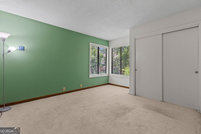 890 Muirfield Rdg, Marietta, GA 30068 - unfurnished bedroom featuring a closet, carpet flooring, a textured ceiling, and baseboards