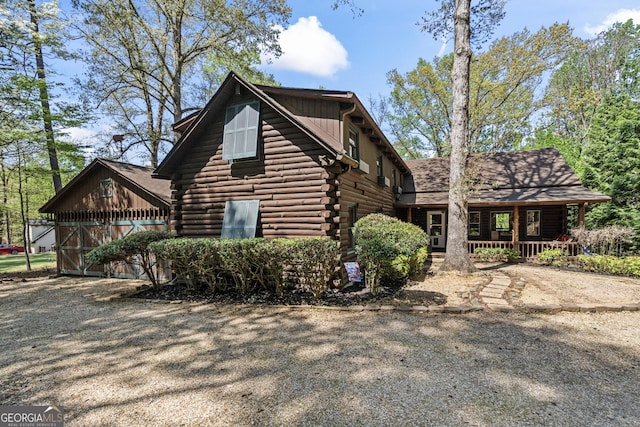 view of home's exterior featuring log siding and covered porch