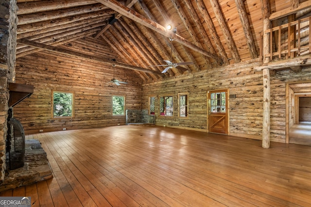 unfurnished living room with wooden ceiling, a ceiling fan, beam ceiling, wood-type flooring, and high vaulted ceiling