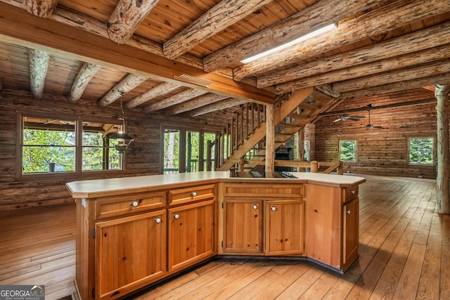 kitchen with open floor plan, light wood-type flooring, beamed ceiling, and wood ceiling
