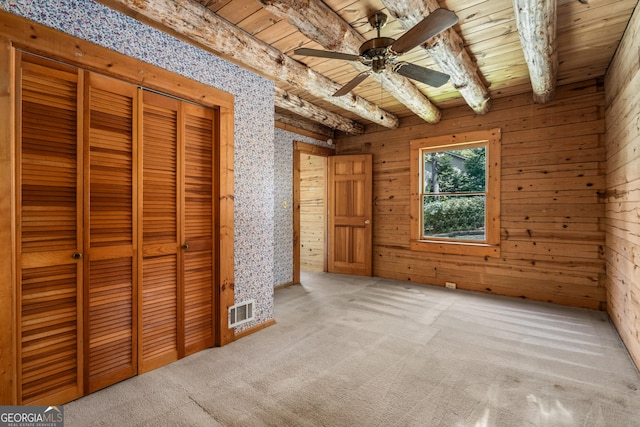unfurnished bedroom with a ceiling fan, visible vents, carpet floors, wooden ceiling, and beam ceiling