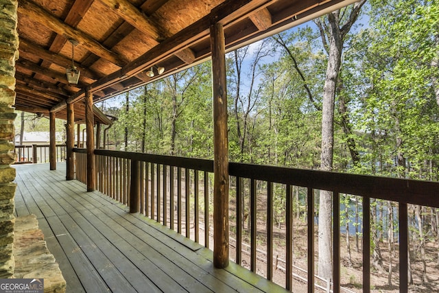 wooden terrace featuring a view of trees