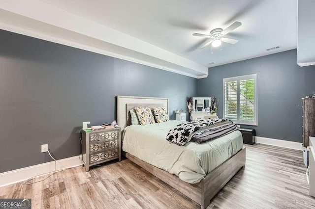 bedroom with visible vents, baseboards, a ceiling fan, and wood finished floors