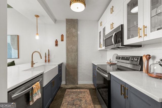 245 N Highland Ave NE Unit 220, Atlanta, GA 30307 - kitchen featuring appliances with stainless steel finishes, light countertops, white cabinetry, a sink, and pendant lighting