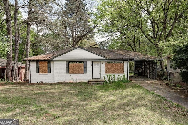 ranch-style house with driveway, an attached carport, a front lawn, and brick siding