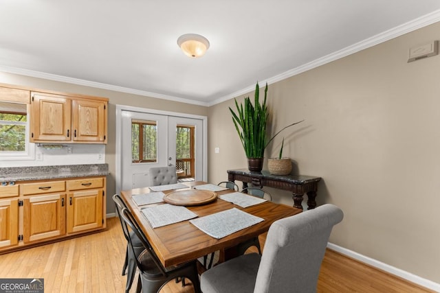 dining room featuring french doors, light wood-style flooring, plenty of natural light, ornamental molding, and baseboards
