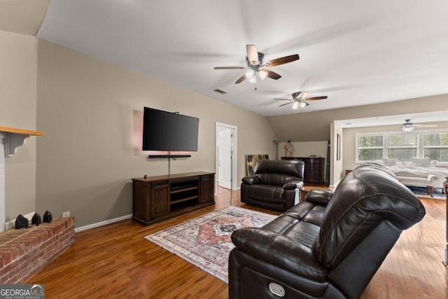 living area featuring ceiling fan, wood finished floors, baseboards, and lofted ceiling