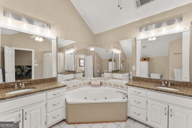 full bathroom featuring lofted ceiling, a jetted tub, toilet, tile patterned flooring, and two vanities