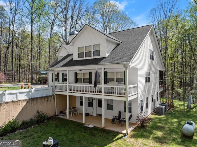 back of property featuring a patio area, a chimney, and roof with shingles