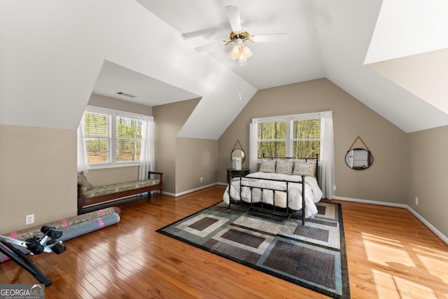 bedroom with multiple windows, wood finished floors, vaulted ceiling, and ceiling fan