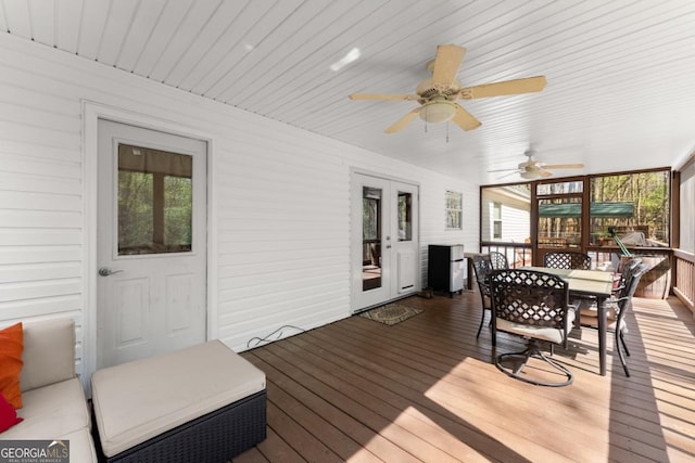 deck with outdoor dining space and a ceiling fan