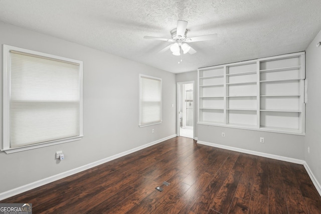 empty room featuring baseboards, hardwood / wood-style flooring, a textured ceiling, and a ceiling fan