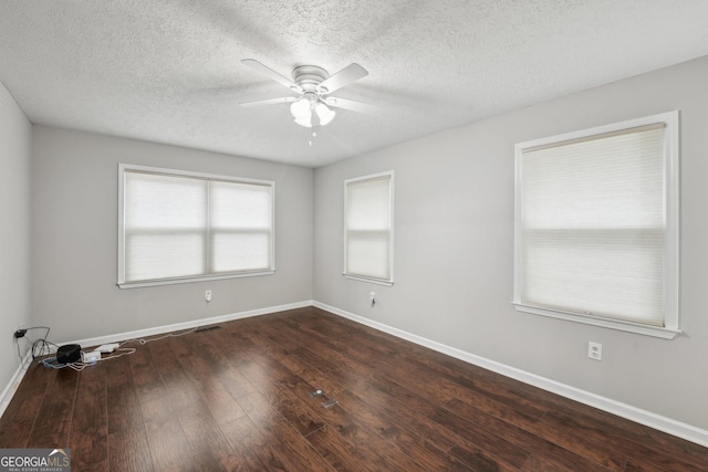 unfurnished room with a textured ceiling, a ceiling fan, visible vents, wood-type flooring, and baseboards