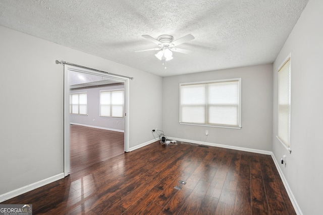 spare room with hardwood / wood-style floors, baseboards, a ceiling fan, and a textured ceiling