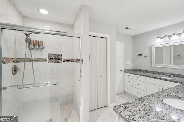 full bath featuring vanity, visible vents, a closet, and a stall shower