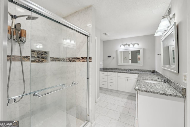 full bath featuring a shower stall, vanity, and visible vents